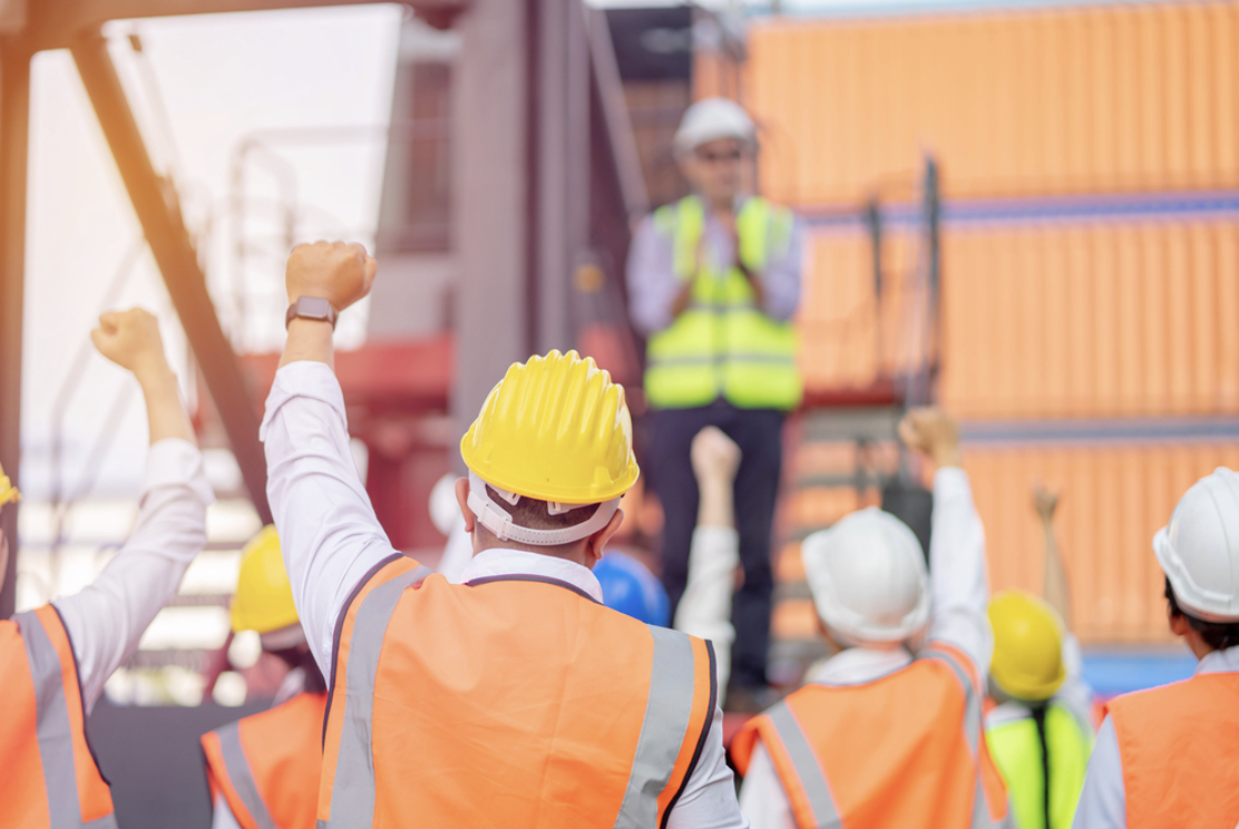 Union workers at port with fists up in the air